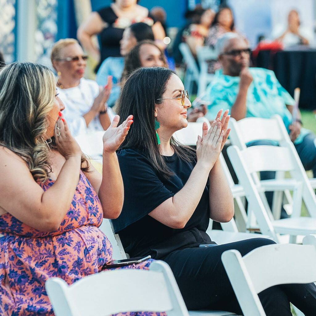 A crowd of people happily applaud