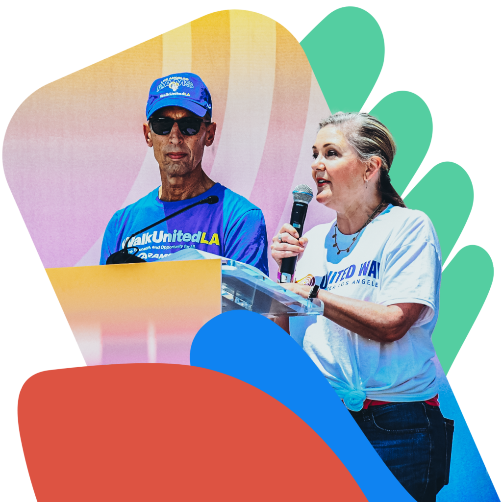 United Way representatives speak into a microphone at the podium for the centennial festival celebration