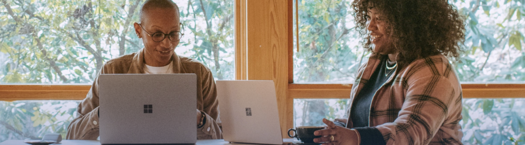 two women working together on their laptops